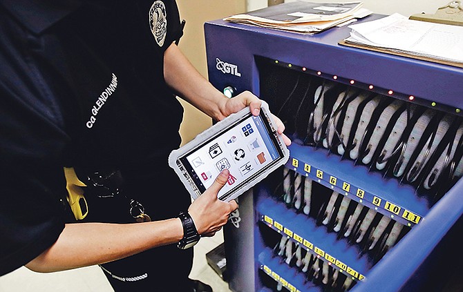 New Hampshire Department of Corrections Officer Glen Dinning puts a tablet back into a charging cabinet at the Corrections Transitional Work Center, a low risk security section at the New Hampshire State Prison for Men, in Concord, NH. Inmates across the country are getting access to technology via tablets in an effort to help their education, keep them connected to family and reduce noise and violence in prison. Photo: Charles Krupa/AP