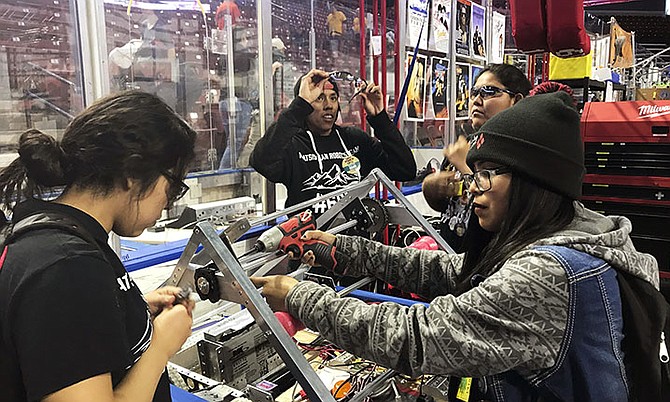 From left, Navajo Mountain High School students Nahida Smith, Myra King and Breana Bitsinne competing in a Utah regional robotics competition in West Valley City, Utah in March. The team, from a remote town in southern Utah, is now headed to an international robotics competition next week in Mexico City, Mexico. They were invited to compete in the First Global Challenge, which will draw teams from 190 countries to create robots capable of feeding power plants and building environmentally efficient transmission networks. Photo: Heather Anderson/AP