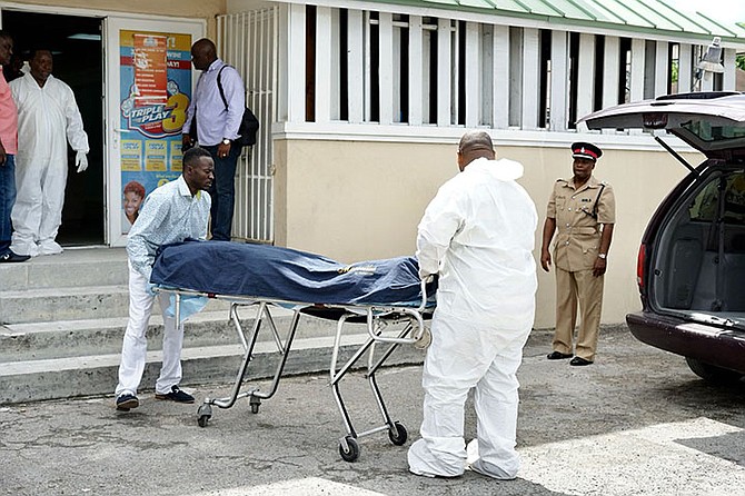 The body is removed from the scene on East Street. Photo: Terrel W Carey/Tribune staff