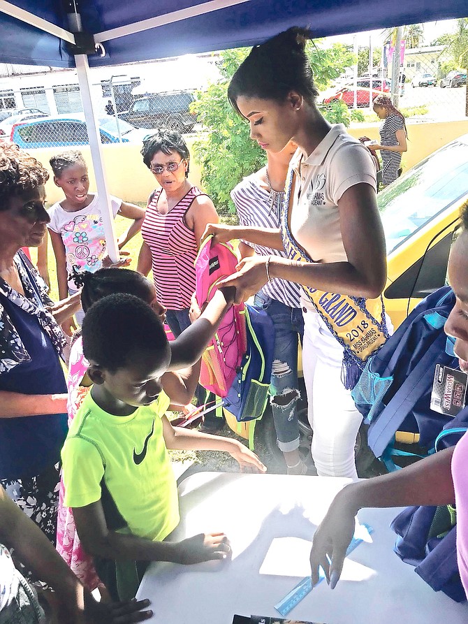 Miss Bahamas Grand Dannise Bain hands out backpacks at her first back-to-school event.

