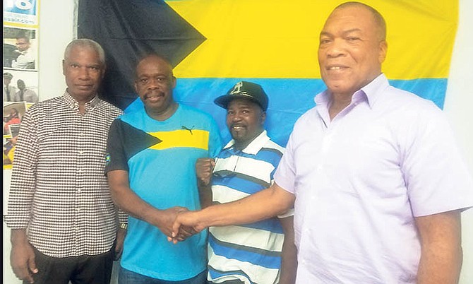 Newly elected president Vincent Strachan shakes hands with outgoing president Wellington Miller as Pat Strachan and Quincy Pratt look on.