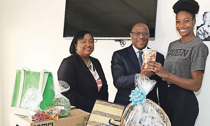 Minister of Agriculture and Marine Resources Michael Pintard presents Shaunae Miller-Uibo with a bowl of conch salad as his Permanent Secretary Phedra Rahming looks on. Photo Patrick Hanna
