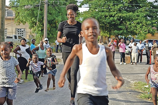 Olympic 400m gold medallist Shaunae Miller-Uibo enjoys a fun sprint with the young children on Sutton Street in the Kemp Road community yesterday. Miller-Uibo was accompanied by her husband, Maicel, and father, Shaun Miller.

Photo: Terrel W Carey Sr/Tribune Staff