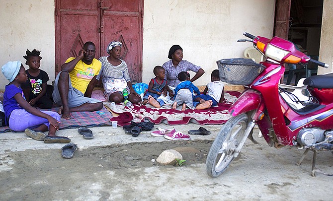 Genson Jean Baptiste and his family gather outside their home on Monday after a 5.9 earthquake that hit Haiti over the weekend, in Port-de-Paix. (AP)