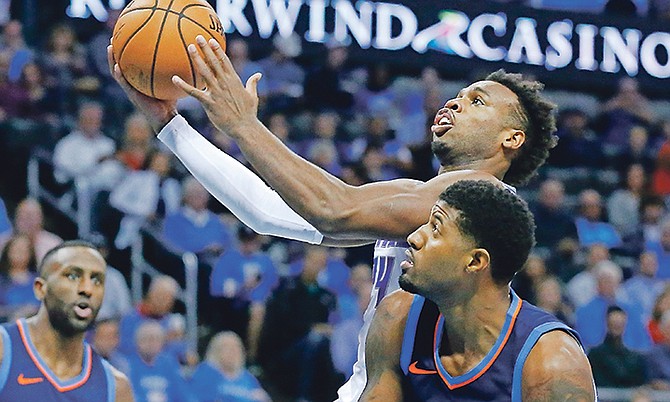 Buddy Hield, centre, shoots between Thunder forwards Patrick Patterson and Paul George.