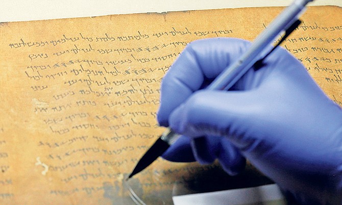 A CONSERVATOR works with a portion of the Dead Sea Scrolls containing Psalm 145 at The Franklin Institute, in Philadelphia.