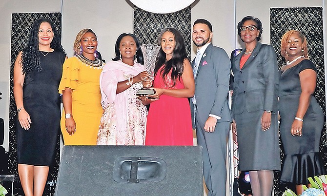 Michelle Butler, centre, received the Prime Minister’s Cup during a National Youth Recognition awards ceremony in late October. She is pictured with Minister of Youth Lanisha Rolle, third from left, and Director of Culture Darron Turnquest, third from right, and other officials. Photo: Eric Rose/BIS