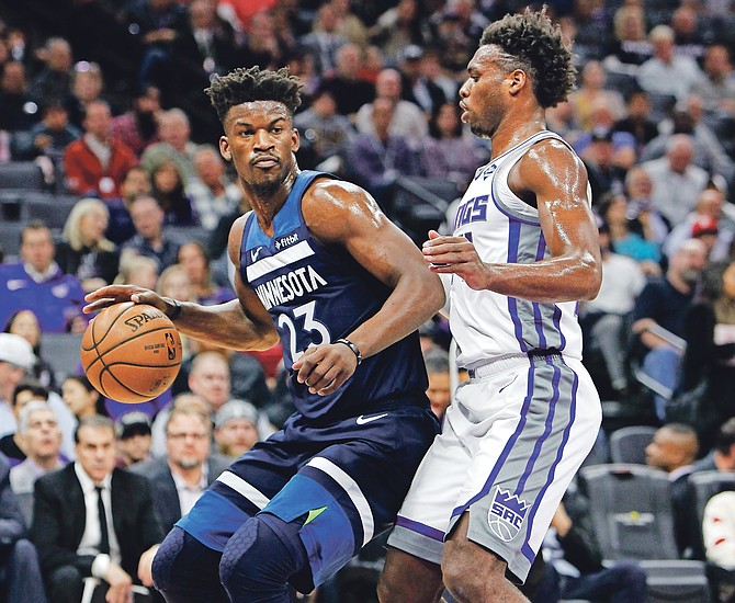 Minnesota Timberwolves guard Jimmy Butler (23) battles for position against Sacramento Kings guard Buddy Hield (24) in the first half on Friday night.