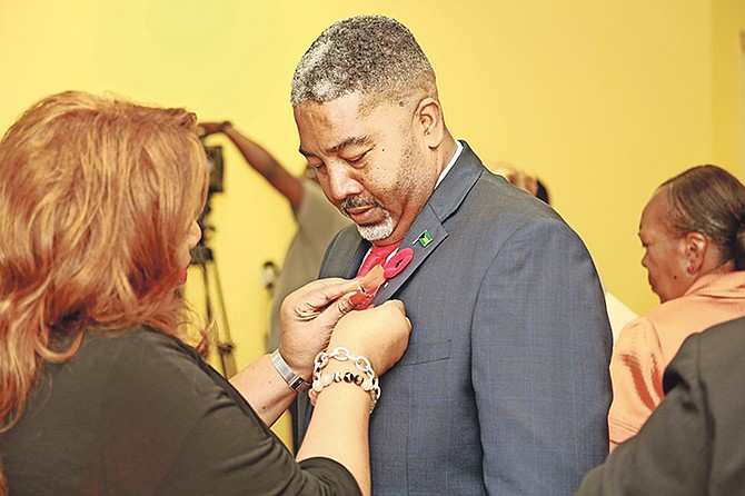 Minister of Social Services and Urban Development Frankie Campbell receiving a pin before speaking at the Elimination of Violence against Woman and Girls Press Conference.

Photo: Donavan McIntosh