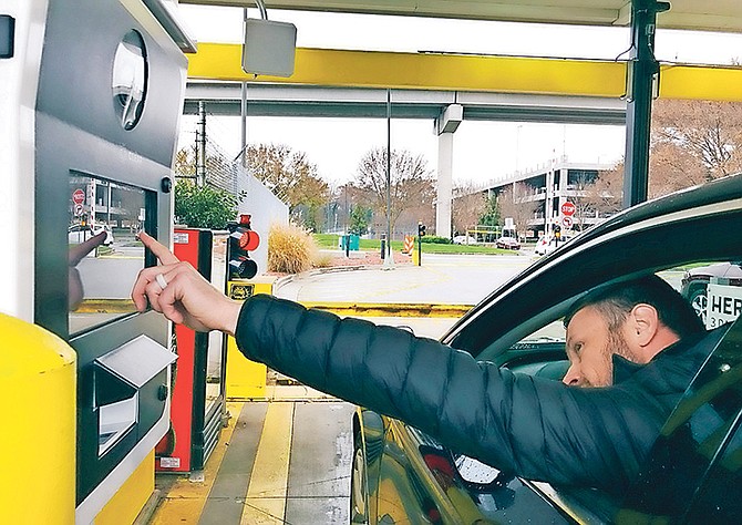 A rental car driver demonstrates a new biometric scanning machine by placing his finger on the reader at the Hertz facility at Hartsfield-Jackson Atlanta International Airport, in Atlanta. In a first for the rental car industry, Hertz is teaming up with Clear, the maker of biometric screening kiosks found at many airports and stadiums. Hertz says the partnership will slash the time it takes to pick up a rental car. Photo: Jeff Martin/AP