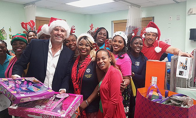 Pictured with Dr Sands is Glen Ward of Bahamas FirstALERT Weather Network, Ltd; nurses from the ward and members of Kiwanis Club of New Providence.