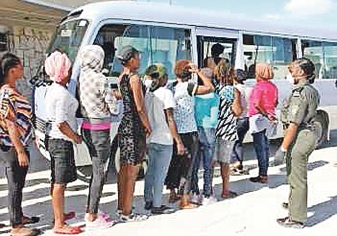 Haitian migrants boarding a bus to be transported to the Carmichael Road Detention Centre. Photo: Chief Petty Officer Jonathan Rolle/RBDF