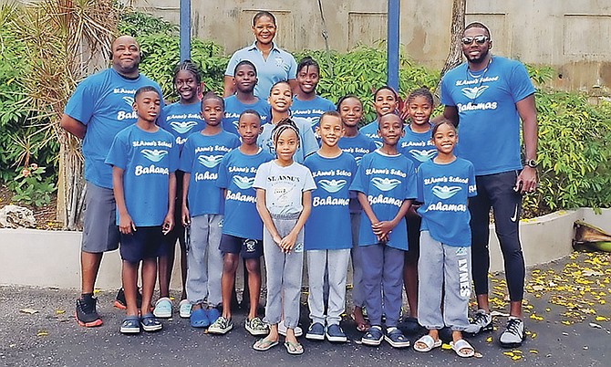 Members of St Anne's swim team along with head coach Dellan Brown (right) and St Anne's Primary Vice Principal Nicholette Archer (centre back) pose above.