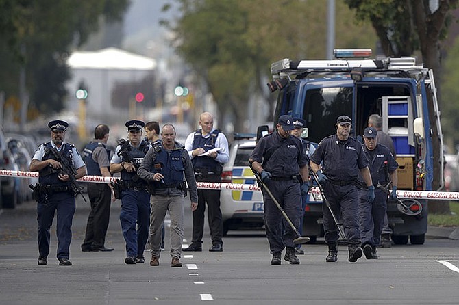 Police officers search the area near the Masjid Al Noor mosque, site of one of the mass shootings at two mosques in Christchurch, New Zealand, Saturday. (AP)