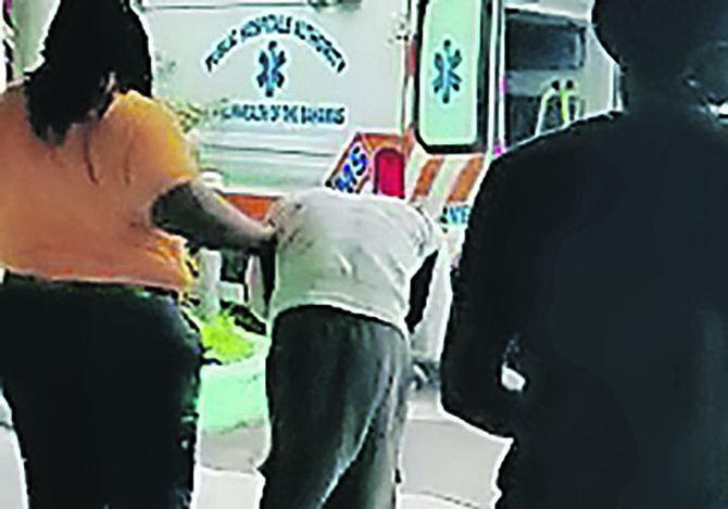 The suspect is helped to a waiting ambulance in a still from the video.