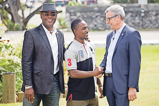 Shervano Johnson, 25, centre, gets words of encouragement from Royal Caribbean International president and CEO Michael Bayley, right. Also pictured is Pinewood MP Reuben Rahming.