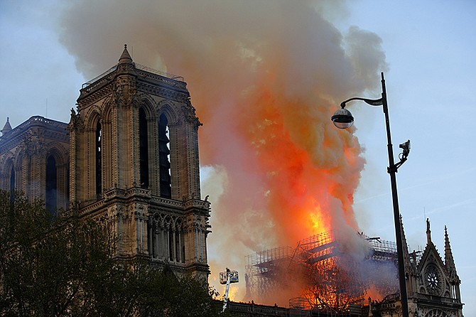 A catastrophic fire engulfed the upper reaches of Paris' soaring Notre Dame Cathedral as it was undergoing renovations Monday, threatening one of the greatest architectural treasures of the Western world as tourists and Parisians looked on aghast from the streets below. (AP Photo/Francois Mori)