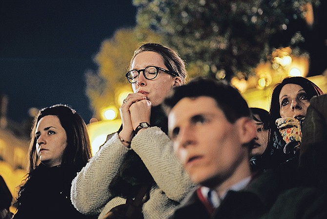 People attend a vigil in Paris after the inferno which engulfed Paris’ iconic Notre Dame cathedral. Photo: Kamil Zihnioglu/AP