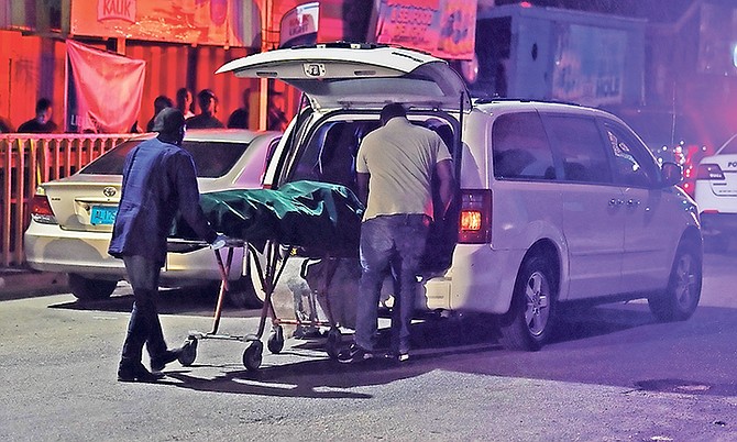 One of the bodies is removed from the scene on Wednesday night. Photo: Shawn Hanna/Tribune Staff