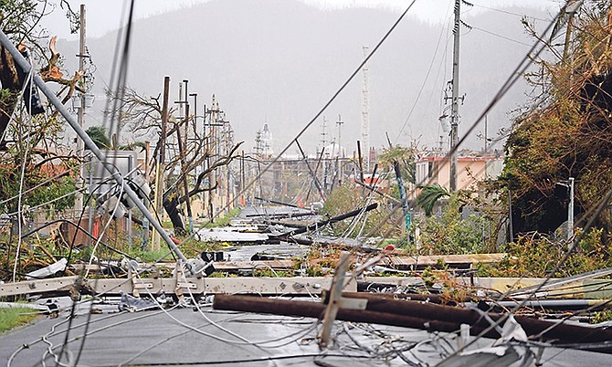 Electricity poles and lines lay toppled on the road after Hurricane Maria hit Puerto Rico in September, 2017.