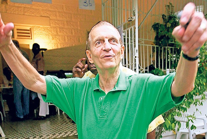Former Jamaican Prime Minister Edward Seaga leaves a polling station after voting in the general election, in Kingston, 2002.