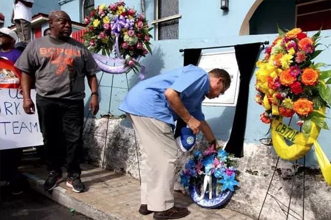 Minister of Labour Senator Dion Foulkes places a wreath in the area where four union members died during last year’s Labour Day Parade, when a car ran into the parade: Tami Gibson, Tabitha Haye, Kathleen Fernander and Dianne Ferguson.   
Photo: Letisha Henderson/BIS
