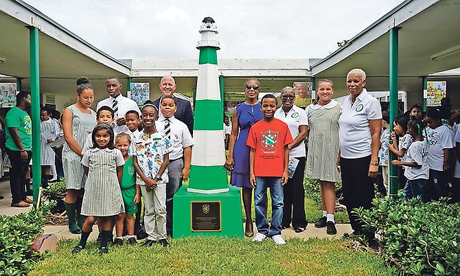 The lighthouse symbol is unveiled at Queen’s College yesterday by Patricia Minnis, wife of Prime Minister Dr Hubert Minnis, to right of the lighthouse. Also pictured is Jordan DeMoux, regional director from the FranklinCovey Foundation, to left of lighthouse.