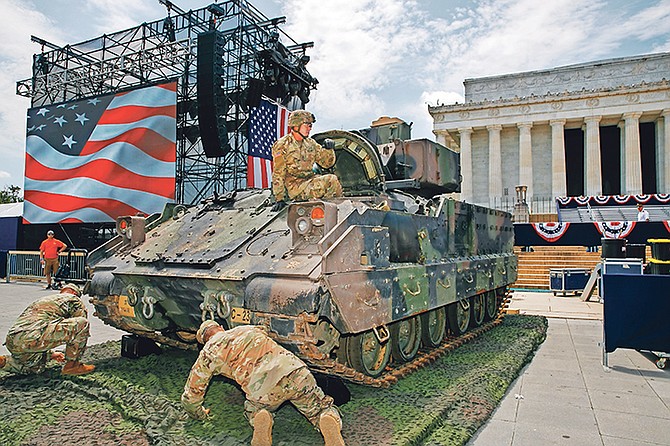 An Army soldier hops out of a Bradley Fighting Vehicle after moving it into place by the Lincoln Memorial yesterday in Washington, ahead of planned Fourth of July festivities with President Donald Trump.