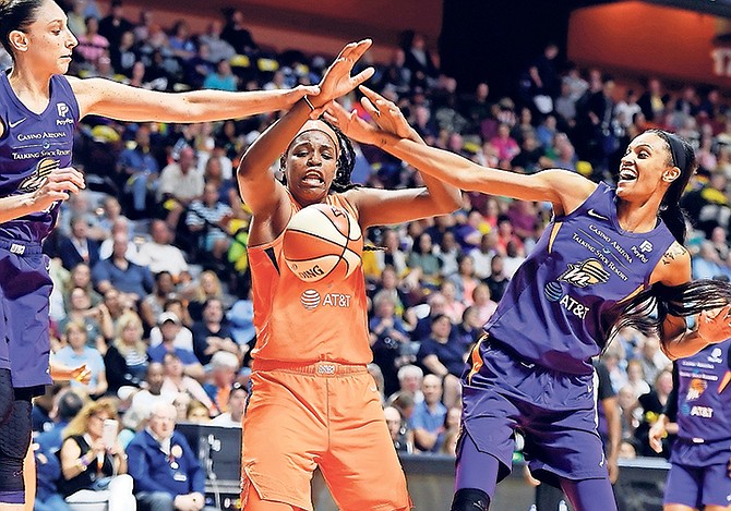 Connecticut Sun centre Jonquel Jones, centre, works between Phoenix Mercury guard Diana Taurasi, left, and forward Dewanna Bonner for a rebound during the first half on Friday, July 12.

(Sean D Elliot/The Day via AP)