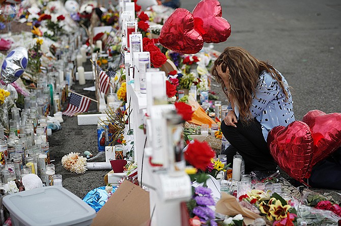 A woman kneels in front of crosses at a makeshift memorial near the scene of the mass shooting at a shopping complex in El Paso, Texas. (AP)