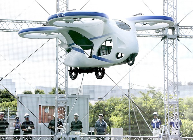 NEC Corp.’s machine with propellers hovers at the company’s facility in Abiko near Tokyo, Monday. The Japanese electronics maker showed a ‘flying car’ – a large drone-like machine with four propellers that hovered steadily for about a minute. (AP Photo/Koji Sasahara)