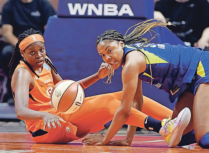 Sun centre Jonquel Jones, left, and Wings centre Kristine Anigwe dive to the floor after a loose ball yesterday.

(Sean D Elliot/The Day via AP)