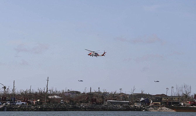 US Coast Guard helicopters fly over Marsh Harbour on Sunday. (AP Photo/Fernando Llano)