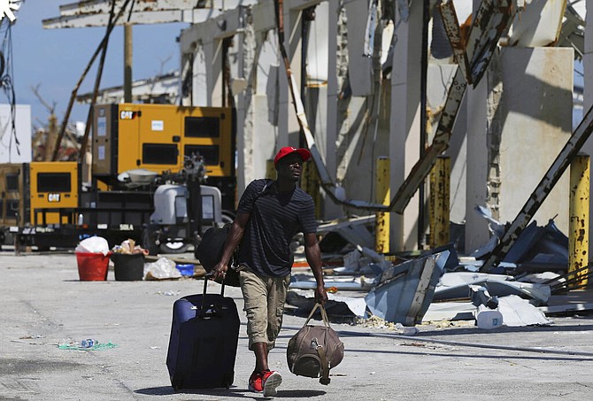 A man in Marsh Harbour carries his belongings to a ferry to depart for Nassau on Sunday. (AP Photo/Fernando Llano)