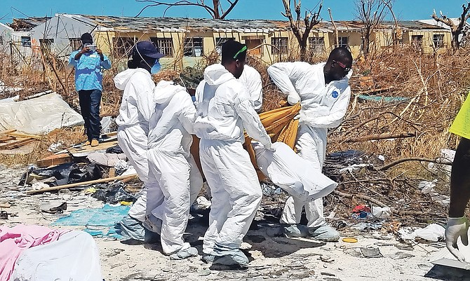 A body is removed from the Pigeon Peas area in Abaco on Monday. Photo: Brent Stubbs