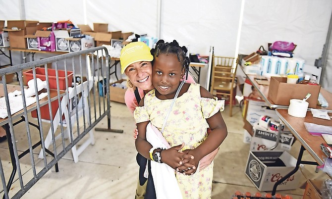 An emotional volunteer embracing an evacuee at Odyssey Aviation. Photo: Shawn Hanna/Tribune Staff