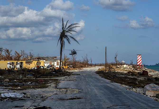 A helicopter flies over High Rock after delivering emergency supplies in the aftermath of Hurricane Dorian in Grand Bahama, Tuesday. (AP Photo / Ramon Espinosa)