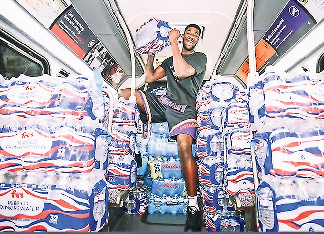 PHOENIX Suns centre Deandre Ayton (above and below) lends a hand during the supplies donation drive at Fry’s grocery store in the Phoenix area.
                                                                                                                                                                                                           Photos: Phoenix Suns/Twitter