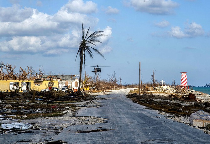 A helicopter flies over the village of High Rock after delivering emergency supplies in the aftermath of Hurricane Dorian In High Rock, Grand Bahama, Tuesday, September 10. (AP Photo / Ramon Espinosa)