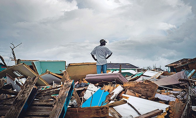 A man stands on the rubble of his home in a shanty town in Abaco after the passage of Hurricane Dorian. Photo: Ramon Espinosa/AP