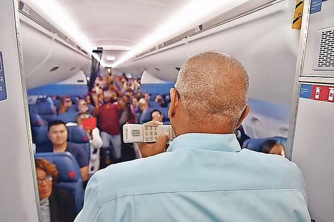 Prime Minister Dr Hubert Minnis addresses a flight of passengers heading into The Bahamas from the United States on Saturday. Photos: Yontalay Bowe/OPM