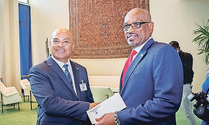 Prime Minister Dr Hubert Minnis receives the donation of $100,000 from Micronesia president David W Panuelo.