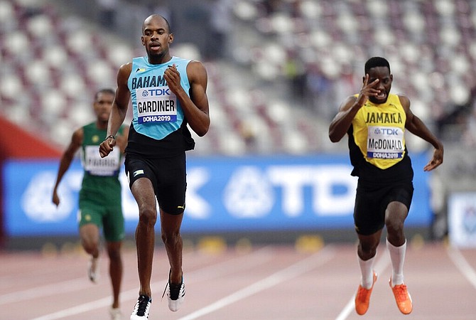 The Bahamas’ Steven Gardiner and Rusheen McDonald of Jamaica race in a men's 400 metre heat at the World Athletics Championships in Doha, Qatar, Tuesday. (AP Photo/Petr David Josek)
