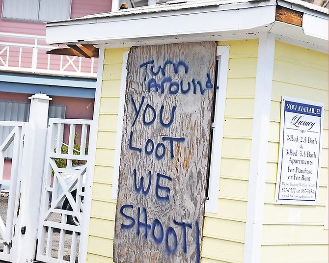 A makeshift sign threatening would-be looters is painted on a board outside an apartment complex in Abaco.
Photo: Shawn Hanna/Tribune staff