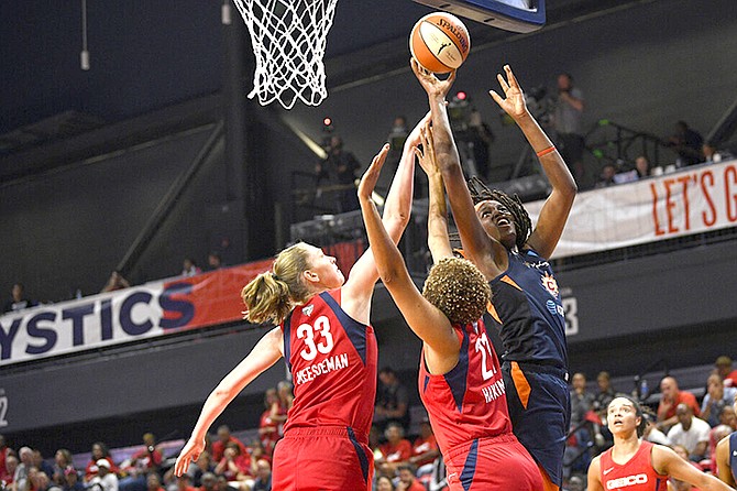 Connecticut Sun forward Jonquel Jones, right, shoots against Washington Mystics centre Emma Meesseman (33) and forward Tianna Hawkins (21) in the first half of Game 2 of basketball's WNBA Finals, Tuesday in Washington. (AP Photo/Nick Wass)