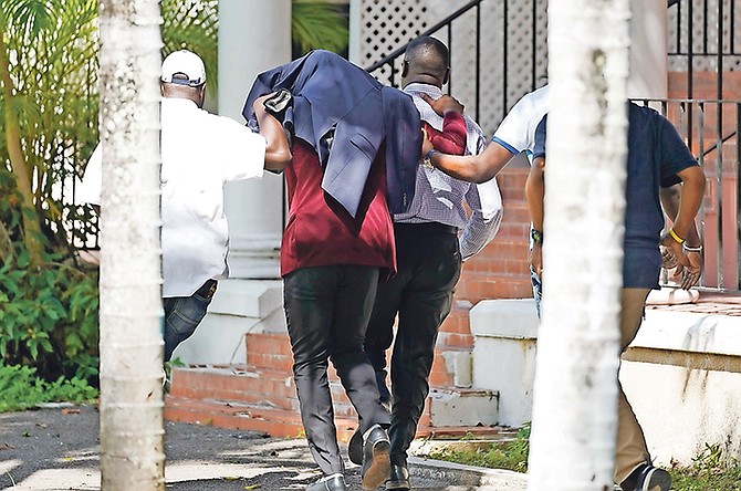 Jonathan Ash outside court at an earlier appearance, with his head covered as he is escorted by police. 
Photo: Terrel W Carey Sr/Tribune Staff