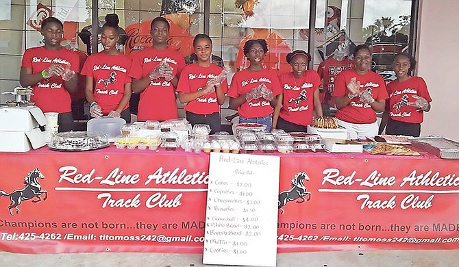 Red-Line Athletics Track Club members pose with items on sale at their bake sale on Saturday.