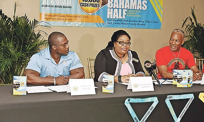 Joy Smith, sales manager at Courtyard Marriott, speaks as Nardo Dean (left) of the Ministry of Tourism and Marcel Major (right), president of the Bahamas Roadmasters, look on.