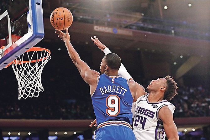 Kings guard Buddy Hield (24) defends against New York Knicks guard RJ Barrett (9) during the second half yesterday.

(AP Photo/Kathy Willens)