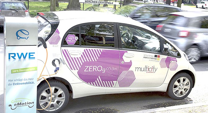 An e-car is connected with a public charge base in Berlin, Germany. German Chancellor Angela Merkel wants to drastically increase the number of charging stations for electric cars in Germany to give consumers more confidence to switch over to electric from internal combustion engines. 
(AP Photo/Michael Sohn)